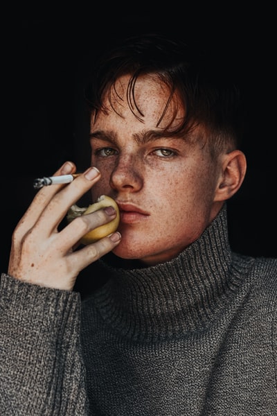 A gray sweater holding a cigarette stick man
